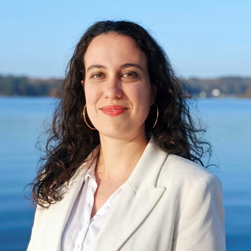 Charlène Salvi, en veste claire, devant un lac